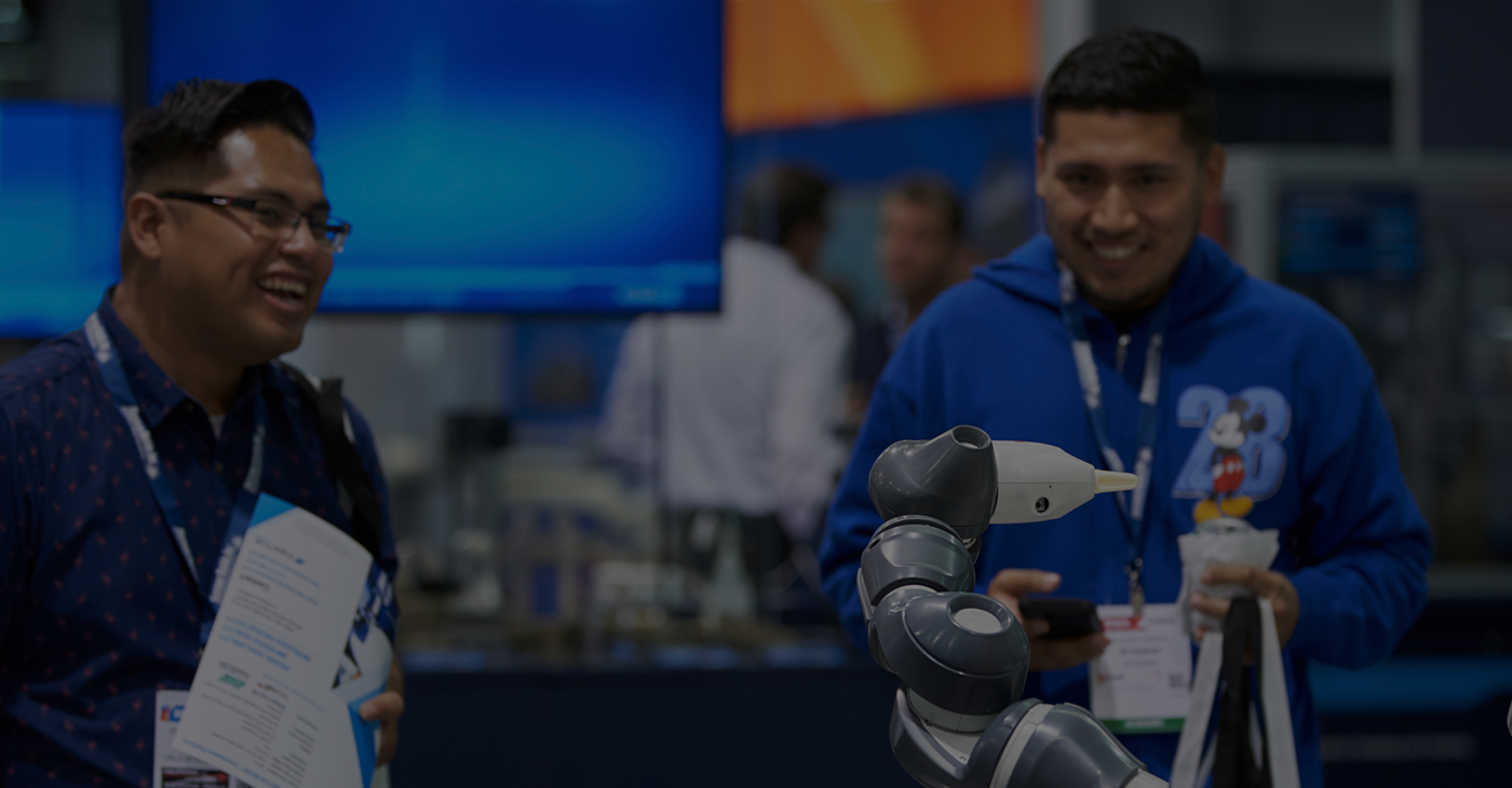 Two attendees enjoying a robot demonstration