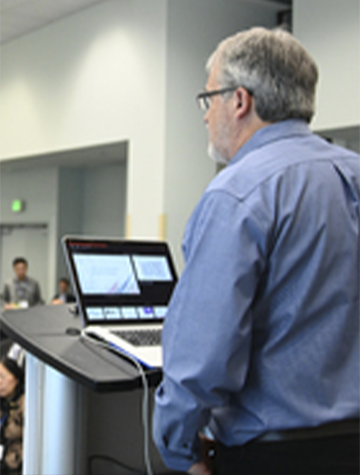 Conference speaker presenting at a conference session 