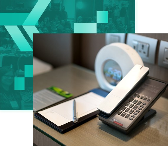 Phone, alarm clock, notepad with pen on a night stand